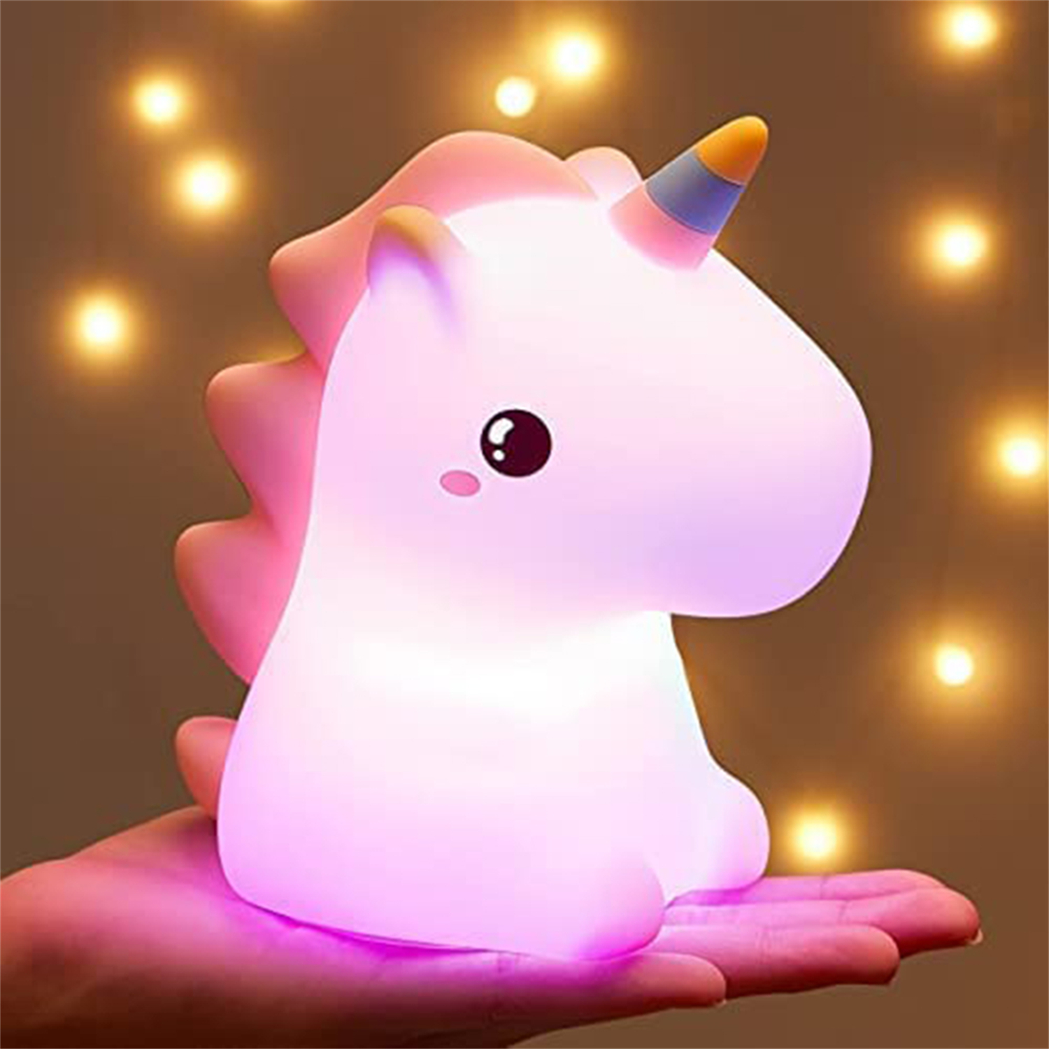Einhorn-Lampe, die rosa in einer Hand leuchtet. Der Hintergrund ist verschwommen.