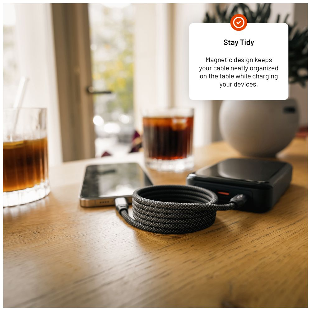 Ein Tisch mit Telefon, Glas und einem schwarzen Kabel. Eine Notiz besagt, dass das Design Kabel ordentlich hält.