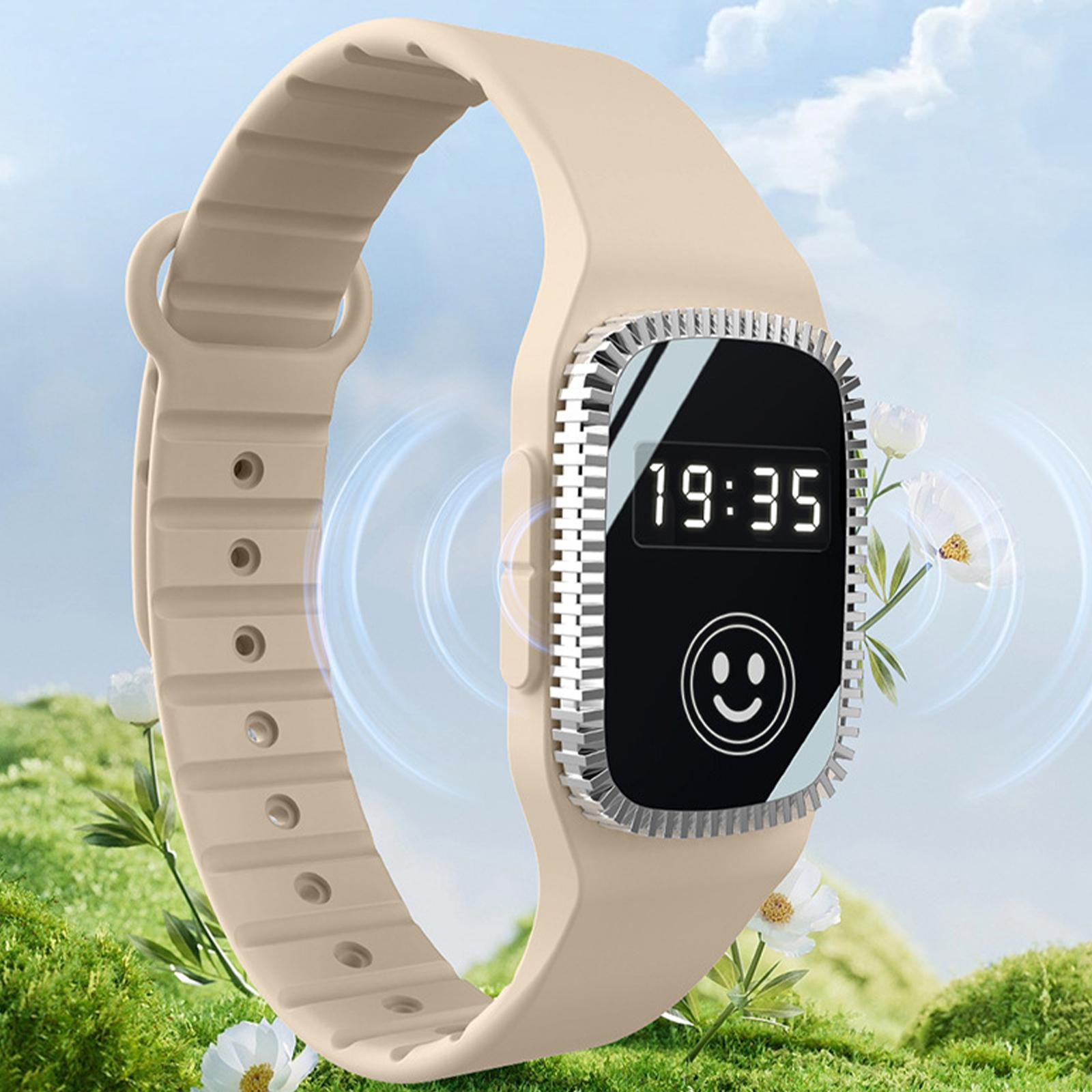 Eine beige Smartwatch mit einem schwarzen Bildschirm, der die Uhrzeit und ein Smiley zeigt.