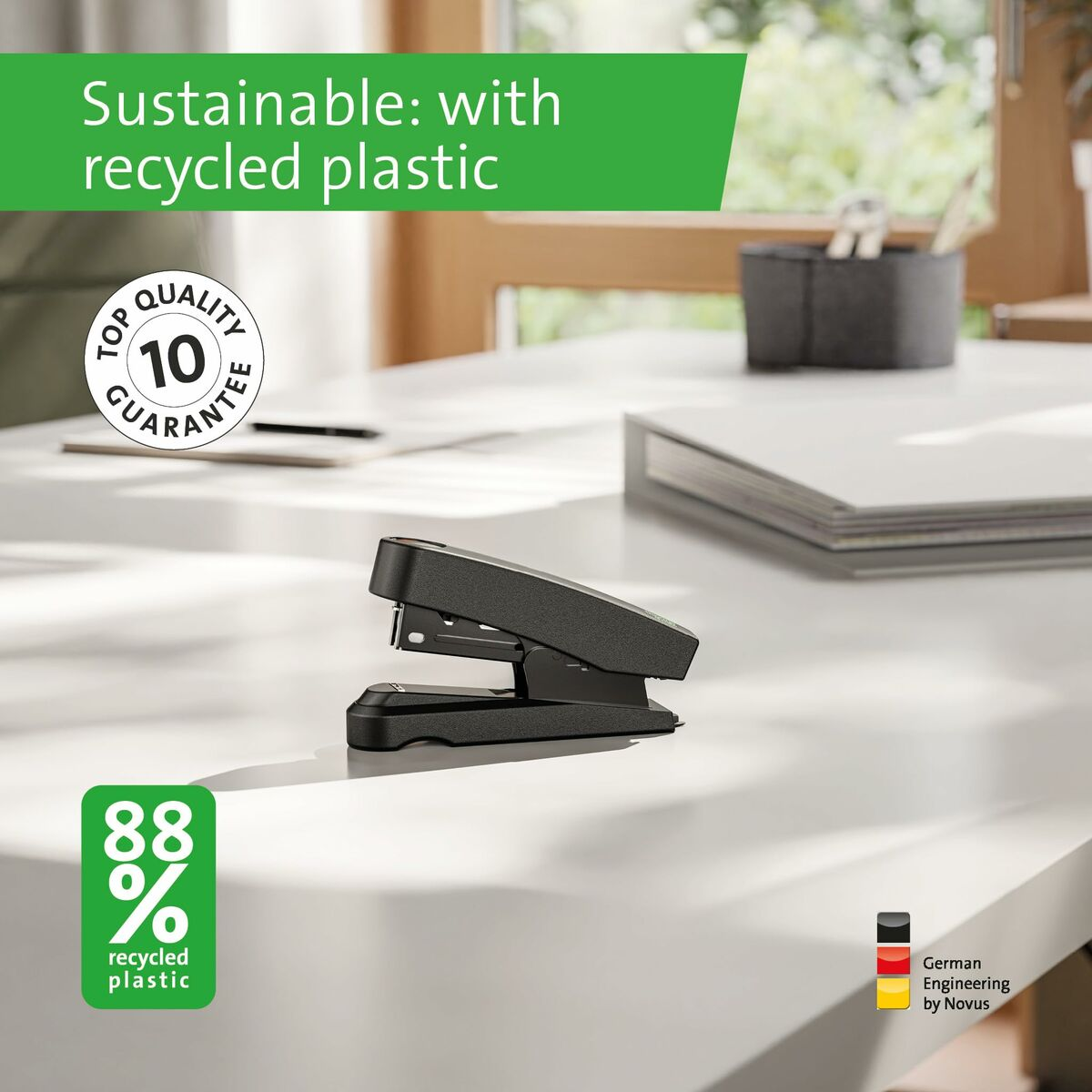 Schwarzer Tacker auf weißem Tisch. Grüner Text: recycelter Kunststoff, 88%.