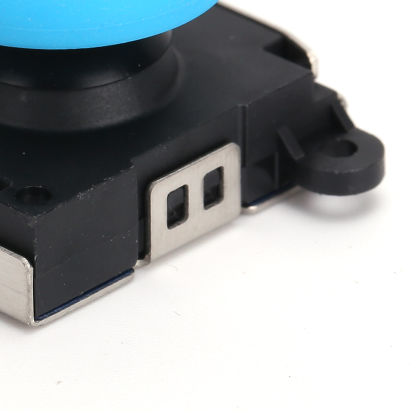 Nahaufnahme eines blauen Joysticks mit schwarzem Sockel und silbernen Metallseiten. Der Joystick ist auf Weiß.