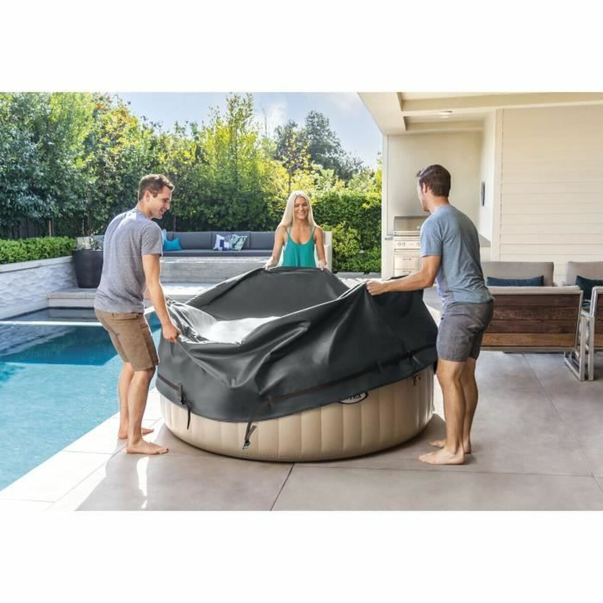 Drei Personen legen eine schwarze Abdeckung auf einen beigefarbenen Whirlpool, in der Nähe von Pool und Grün.