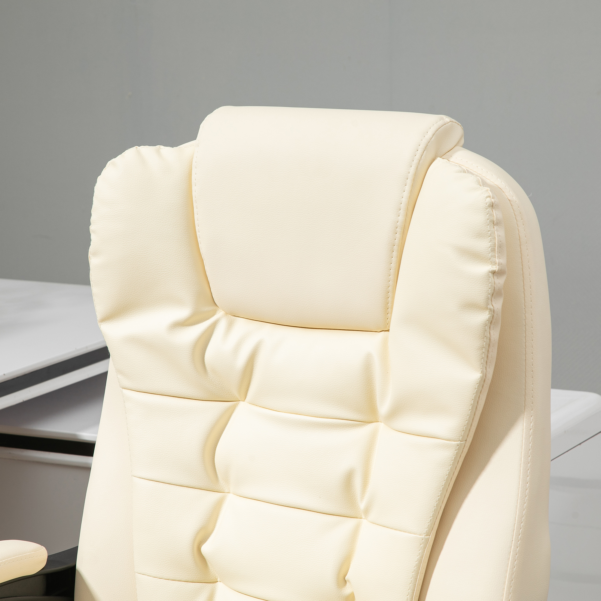 Primer plano del reposacabezas de una silla de oficina blanca. El reposacabezas tiene un patrón acolchado cuadrado.