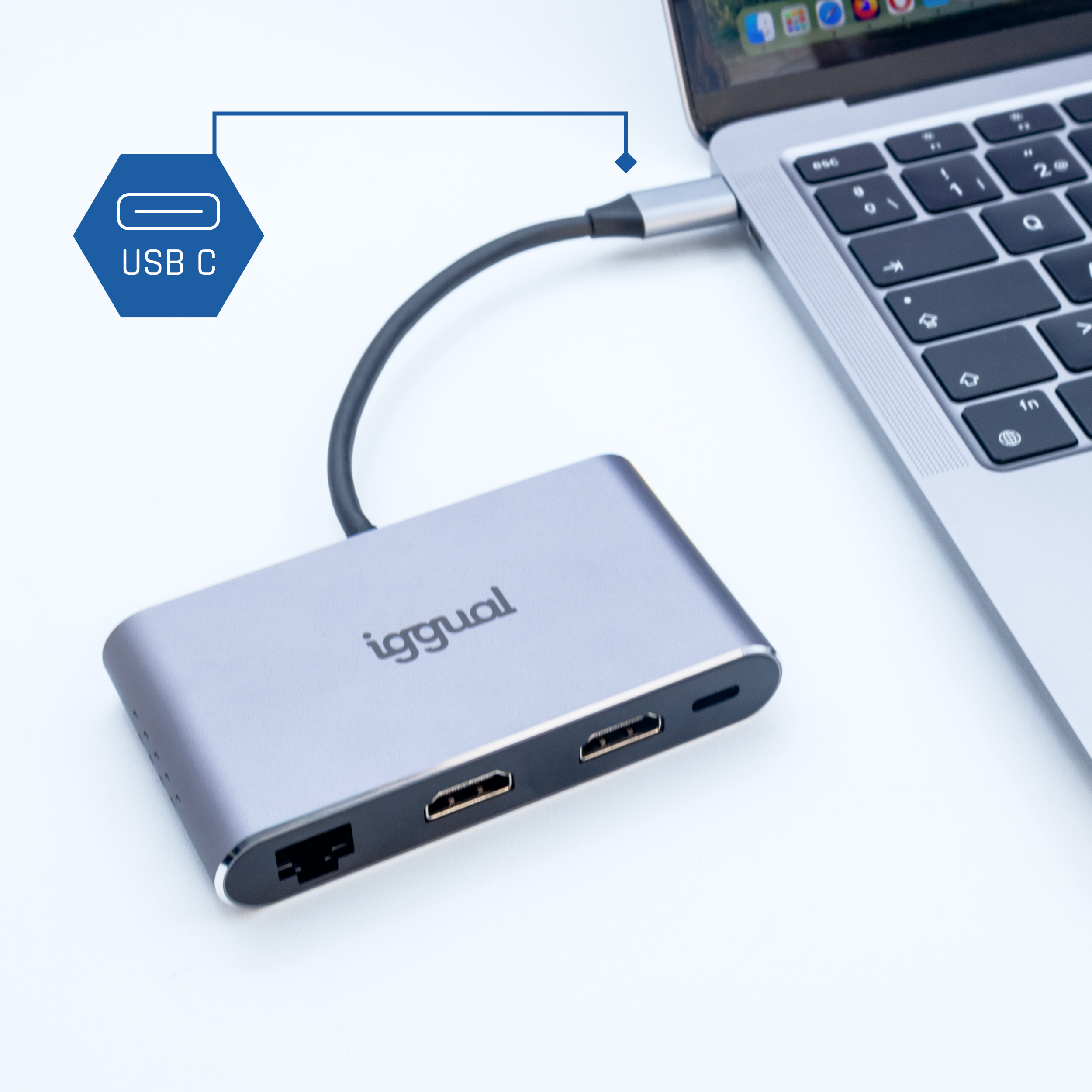 Srebrny adapter podłączony do laptopa przez USB-C, z portami HDMI i Ethernet.