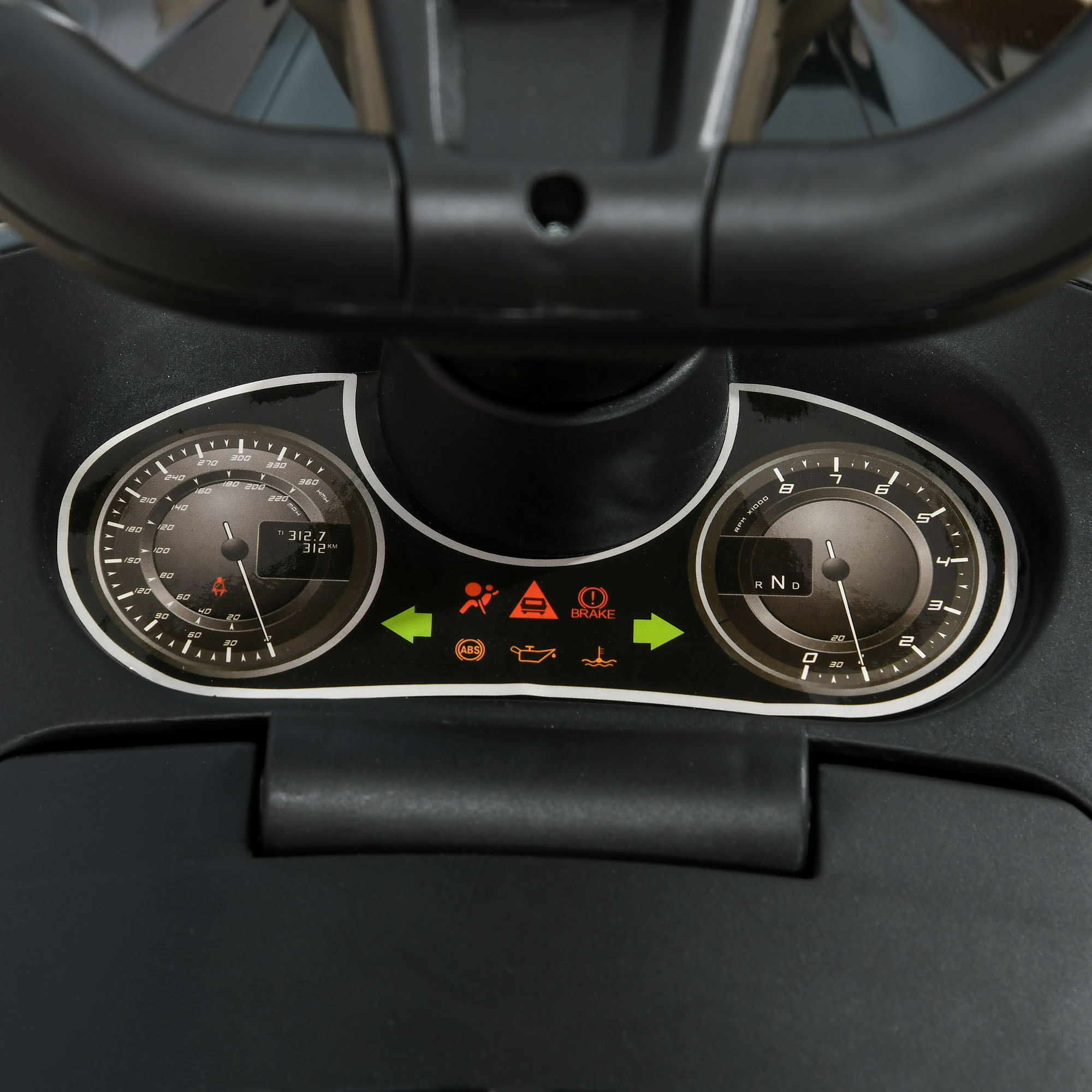 Primo piano del cruscotto di un'auto giocattolo con indicatori e spie di avvertimento, che mostra la velocità e altri dati del veicolo.