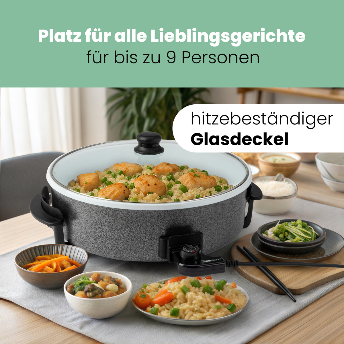 Elektryczny garnek do gotowania z jedzeniem na stole. Zawiera szklaną pokrywę i wiele potraw.