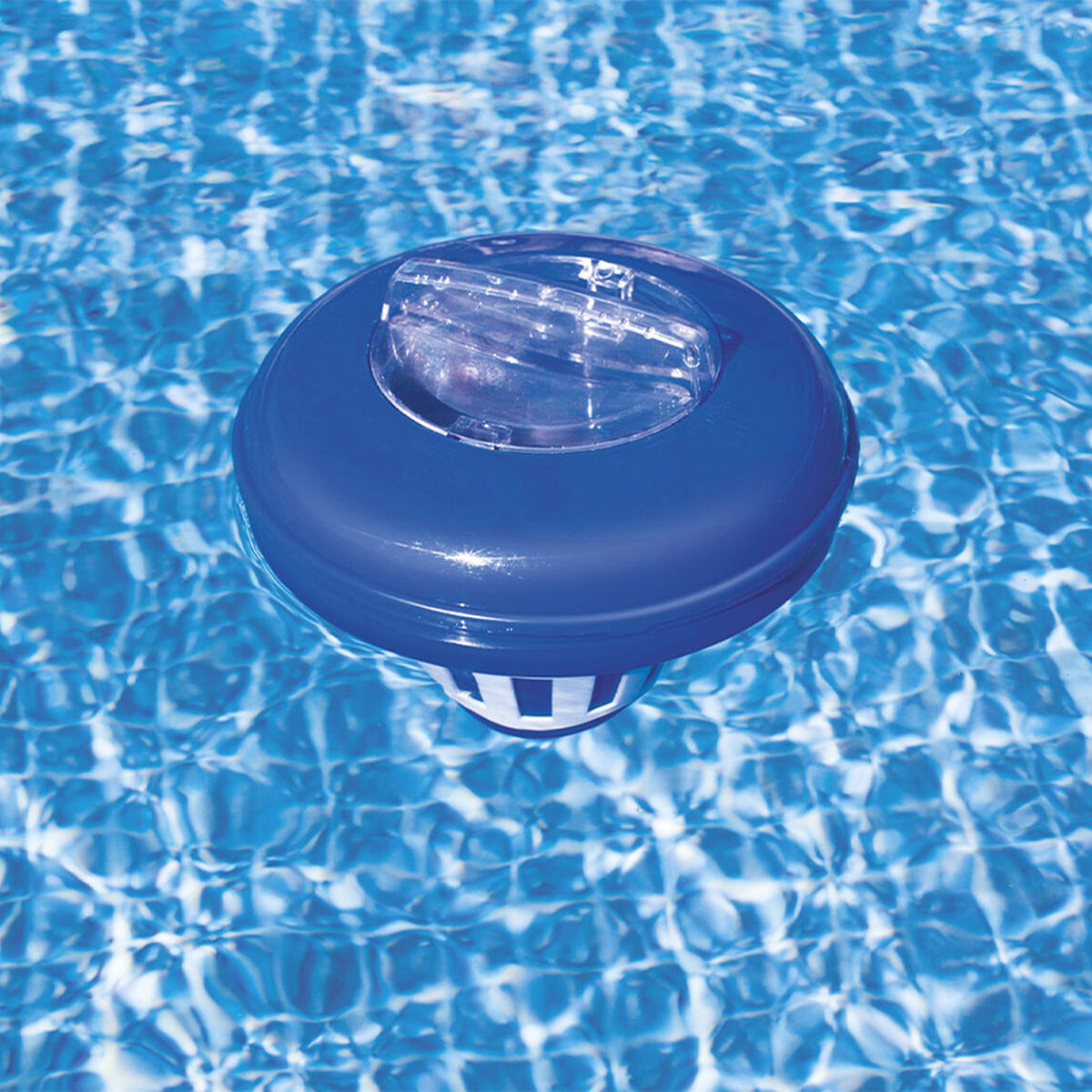 Un distributeur de chlore flottant bleu à la surface d'une piscine avec de l'eau ondulée.