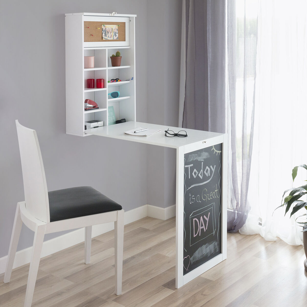 Ein weißer, an der Wand montierter Schreibtisch mit Tafel und Stuhl.