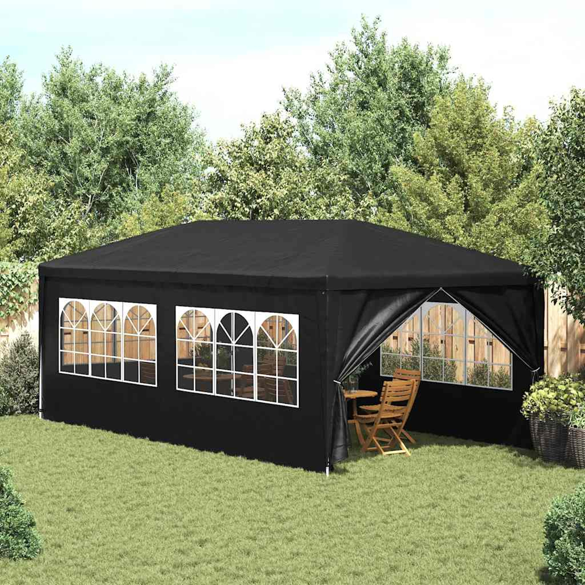 Schwarzer Pavillon mit Bogenfenstern, auf Gras. Tisch und Stühle innen.