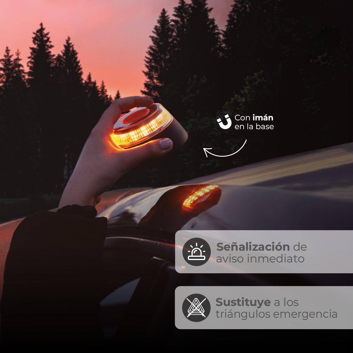 Una mano sostiene una luz de emergencia naranja parpadeante cerca de un coche en una carretera oscura por la noche.