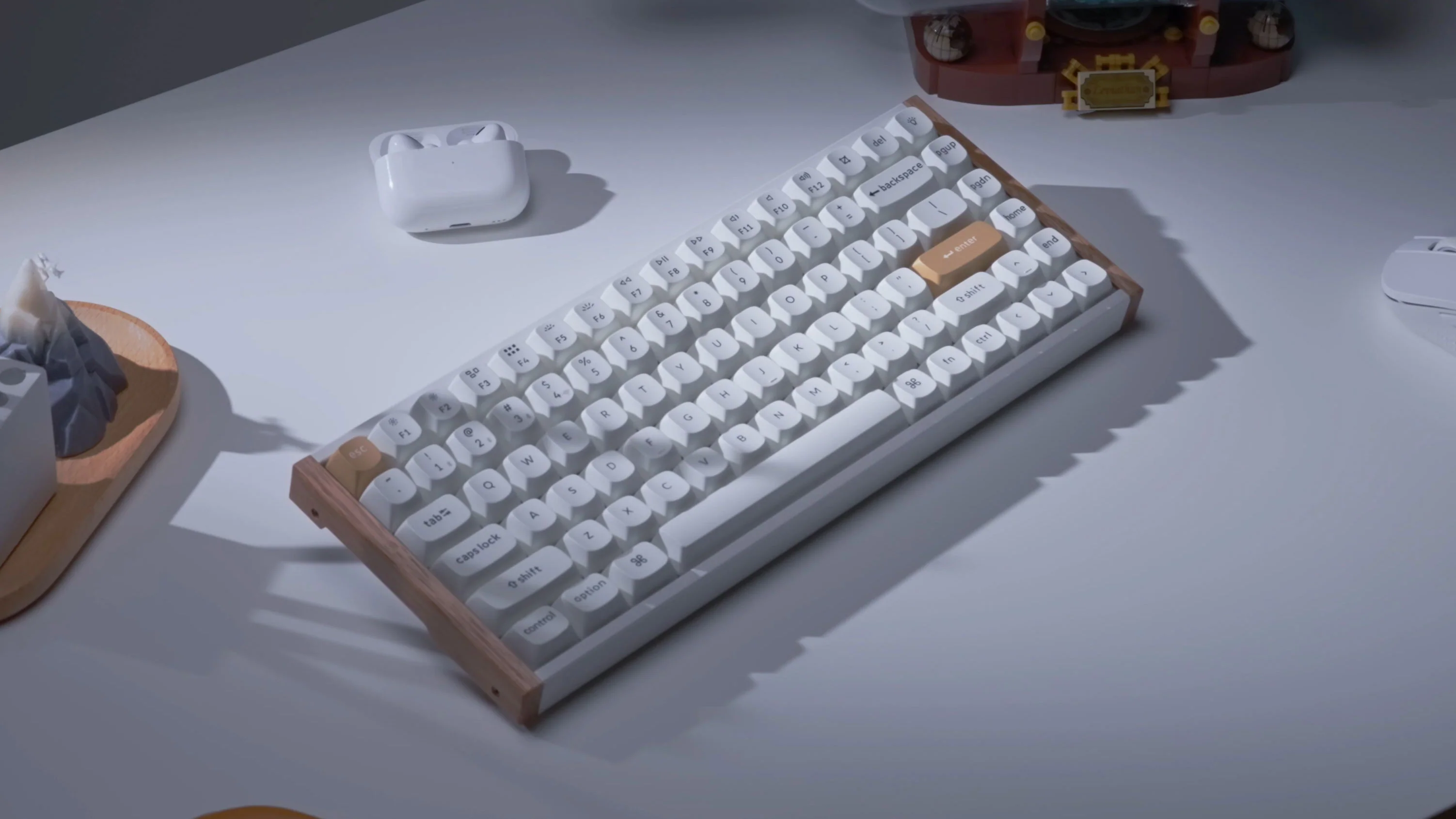 Klawiatura mechaniczna z drewnianą ramą i jasnymi klawiszami na białej powierzchni. W pobliżu znajdują się inne przedmioty.
