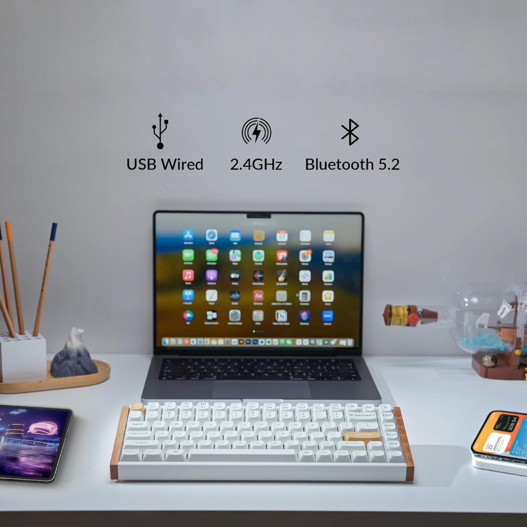 Biurko z laptopem, klawiaturą i innymi urządzeniami. Pokazuje ikony USB, 2.4GHz i Bluetooth 5.2.