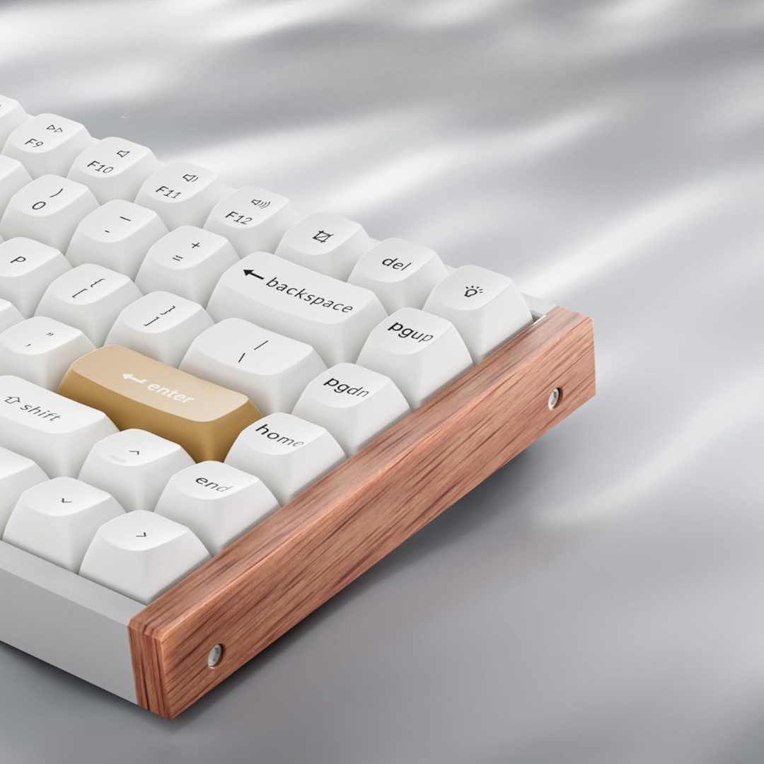 Zbliżenie klawiatury z białymi klawiszami i drewnianą ramą. Klawisz Enter jest brązowy.