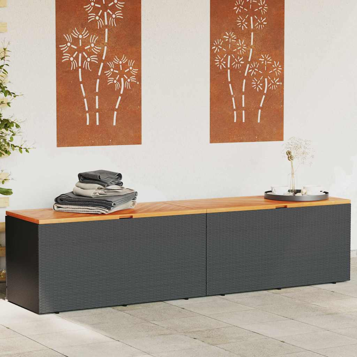 Lange Aufbewahrungsbox mit Holzplatte und grauen Seiten. Zwei Bambus-Kunstwerke an der Wand.