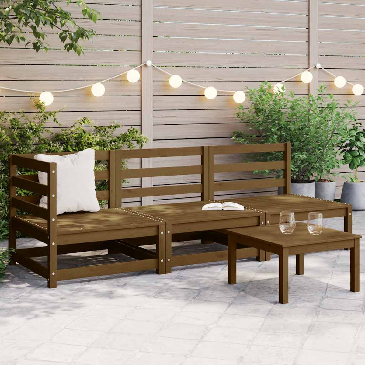 Gartenset aus Holz mit Kissen und kleinem Tisch. Lichterketten und Pflanzen sichtbar.