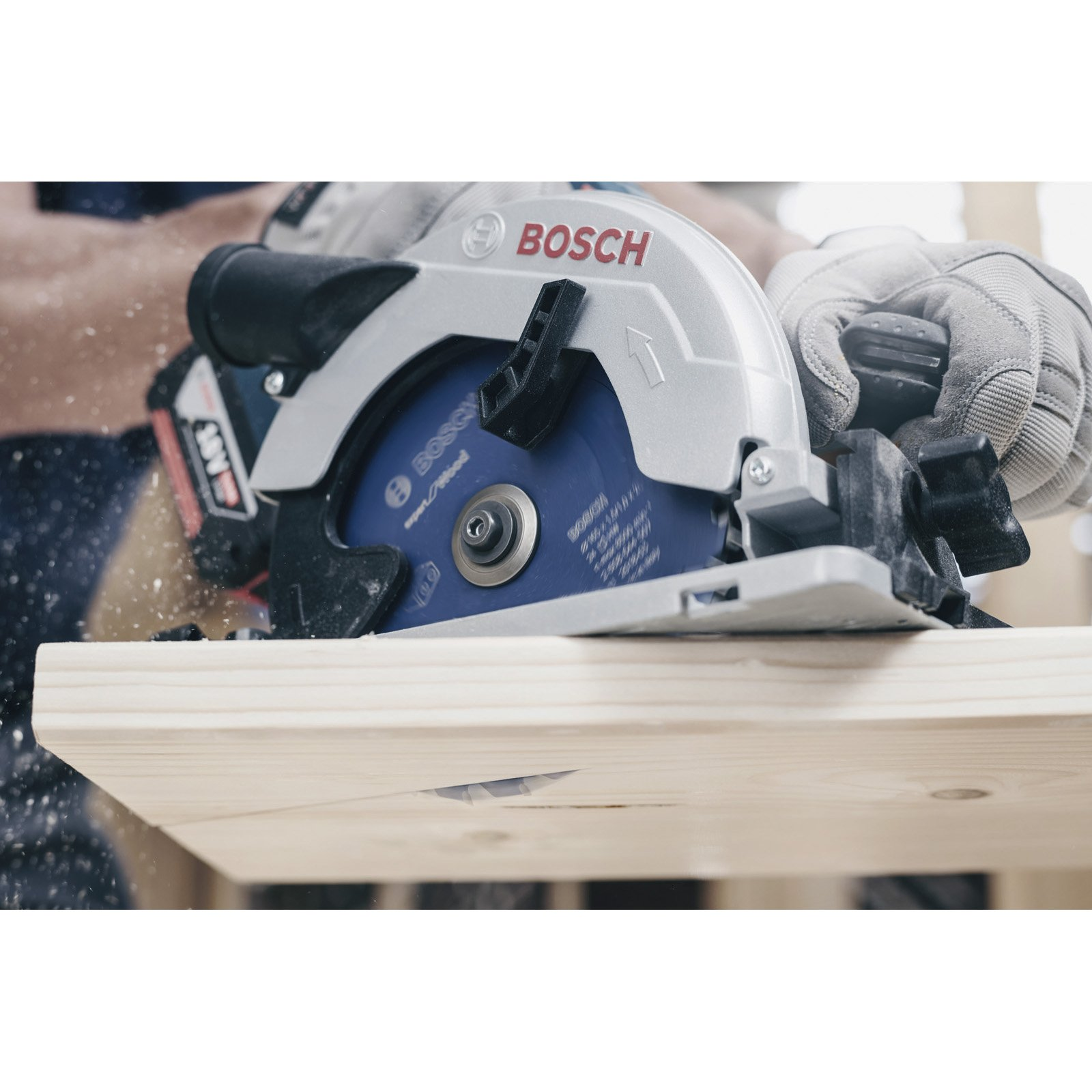 Eine Person schneidet mit einer Bosch-Kreissäge eine Holzbohle. Die Säge ist silber und blau, mit dem Bosch-Logo.