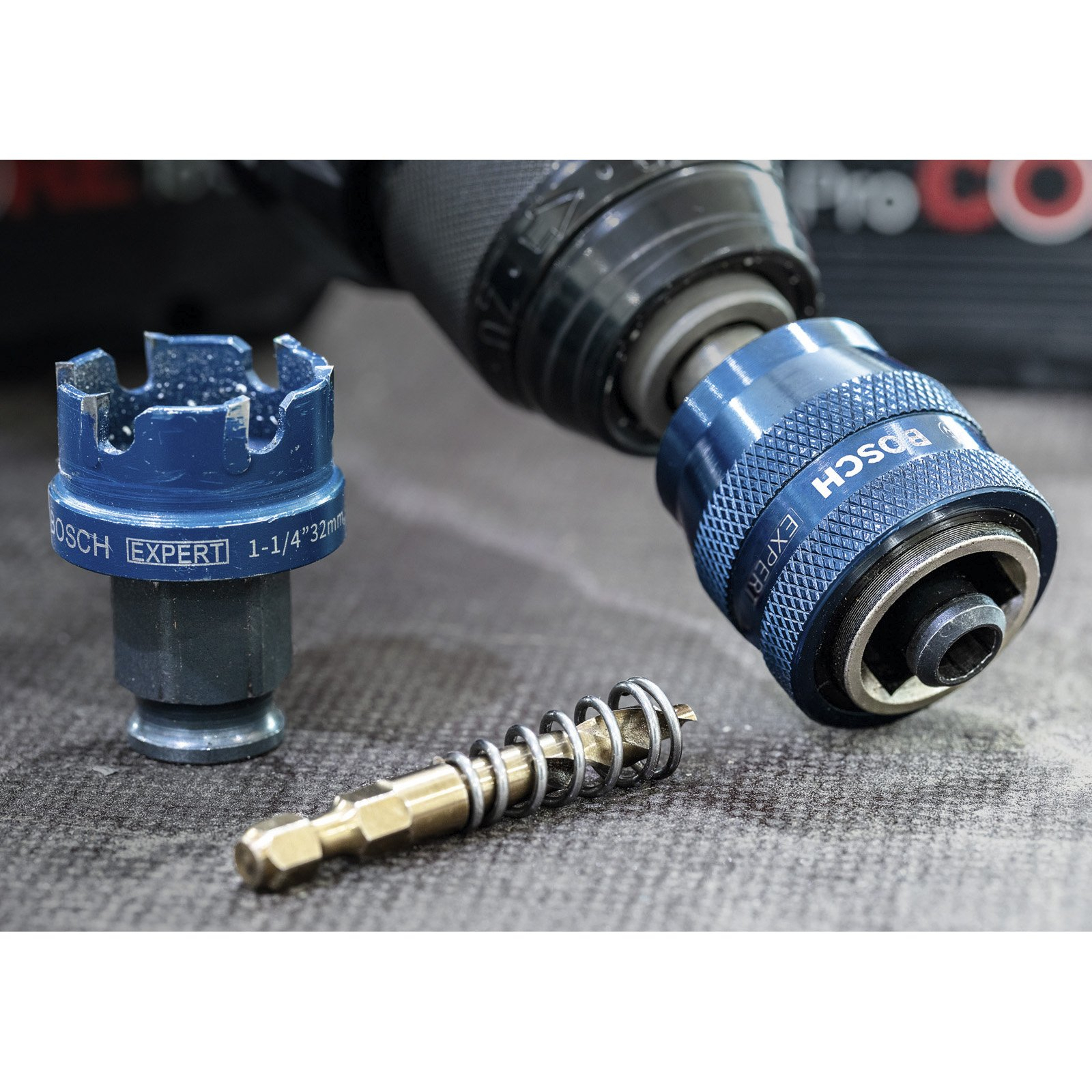 Niebieski zestaw wierteł Bosch z wiertarką i sprężyną. Narzędzia na szarej powierzchni.