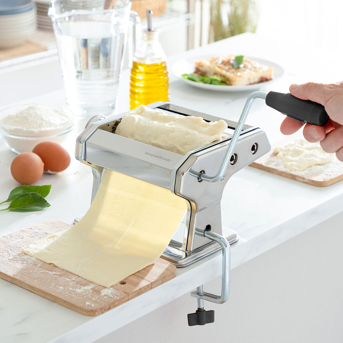 Una persona usa una máquina para hacer pasta. Se procesa masa cruda, se ven ingredientes como huevos, harina y aceite.