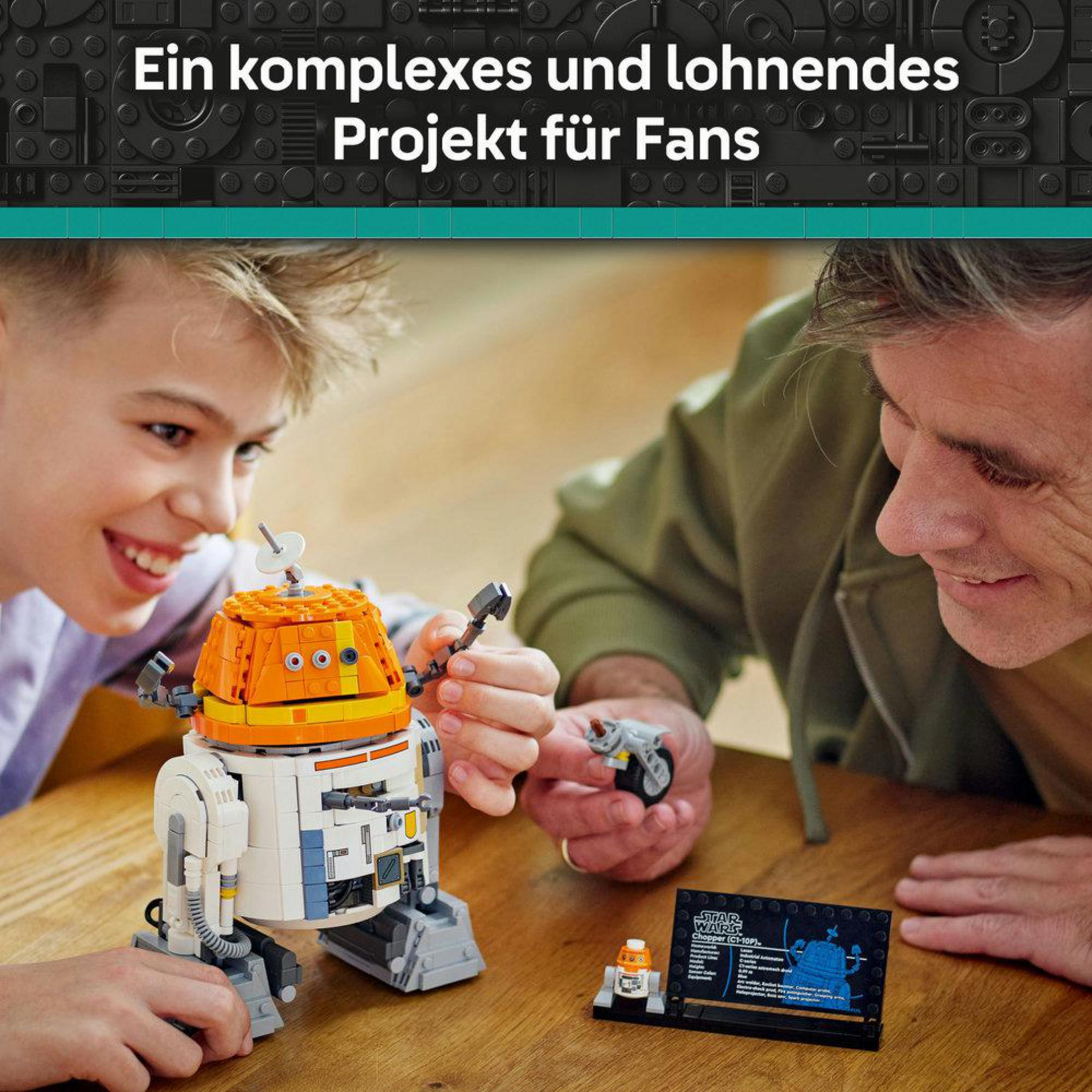 Un padre e hijo construyen un modelo Lego Star Wars Chopper. El modelo es naranja y blanco. La escena es interior.