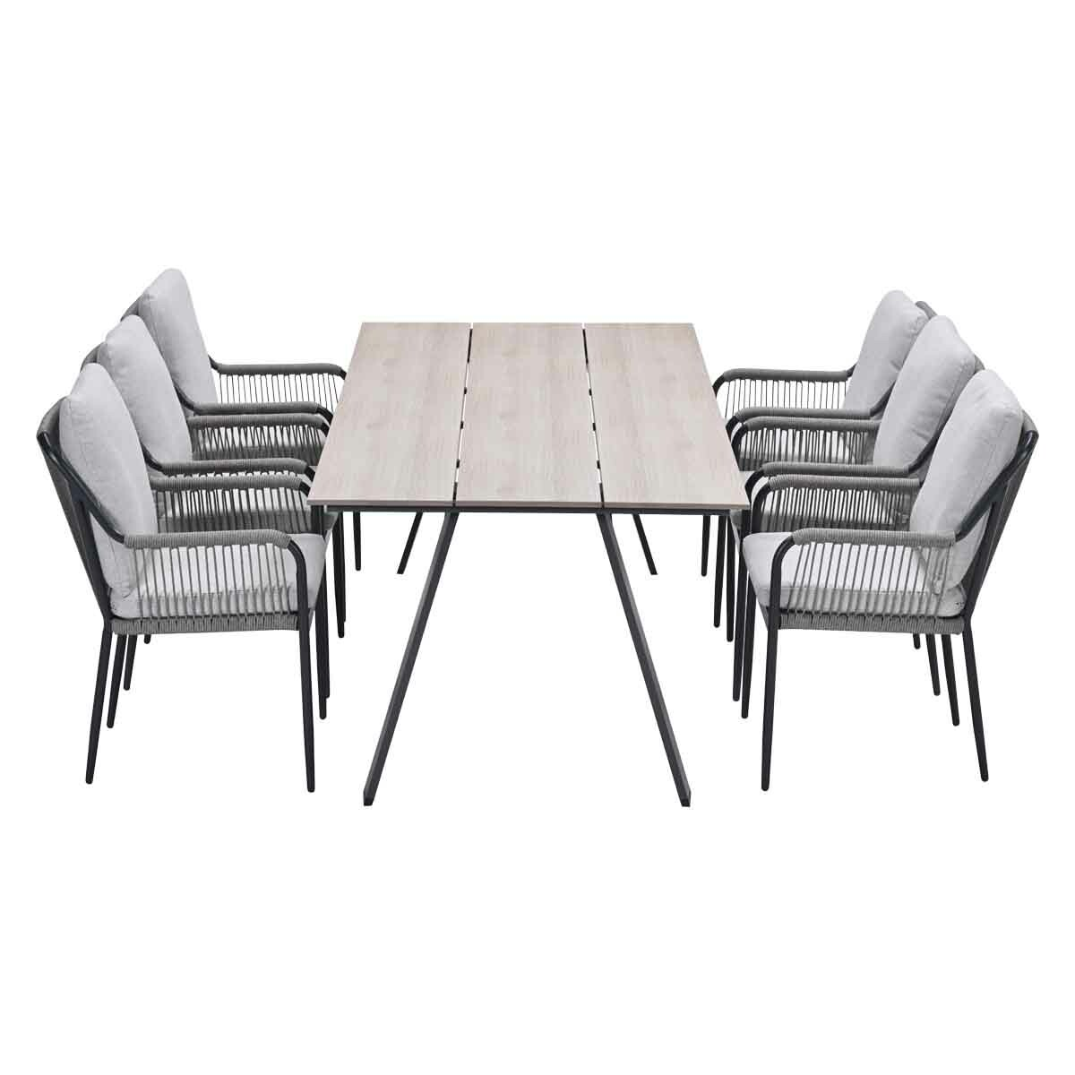 Outdoor dining set: light wood table with six chairs. Chairs have gray cushions and black frames. White background.