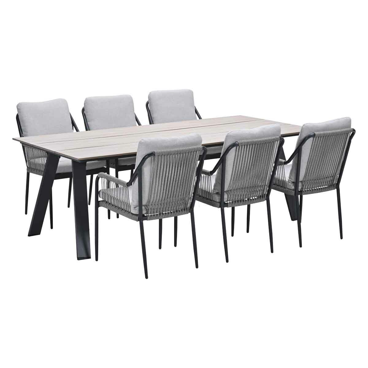 Outdoor dining set: Light wood table, six chairs with grey rope backs and cushions, black frames. White background.
