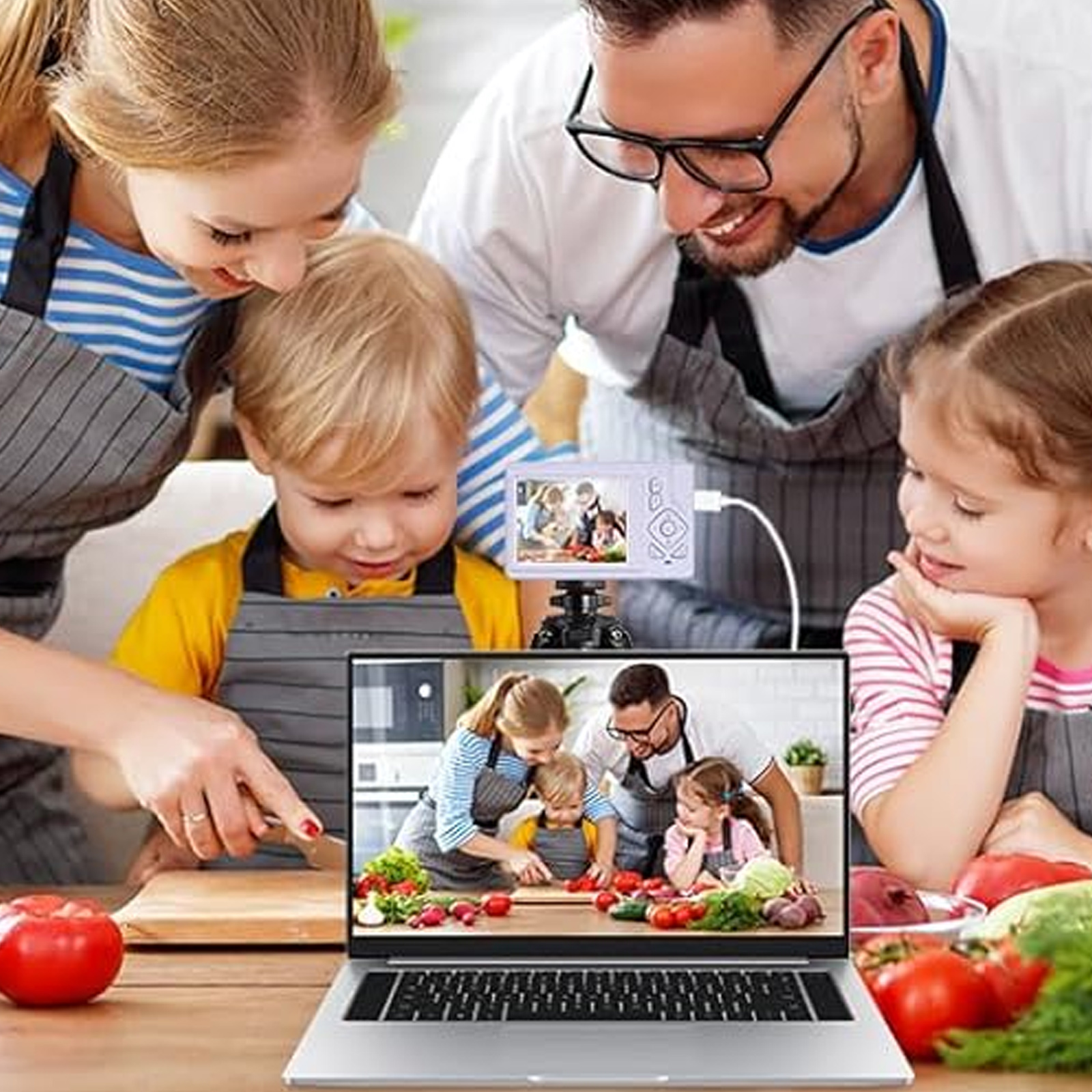 Familie kocht zusammen, mit Laptop und Kamera, die ein Live-Bild zeigen.