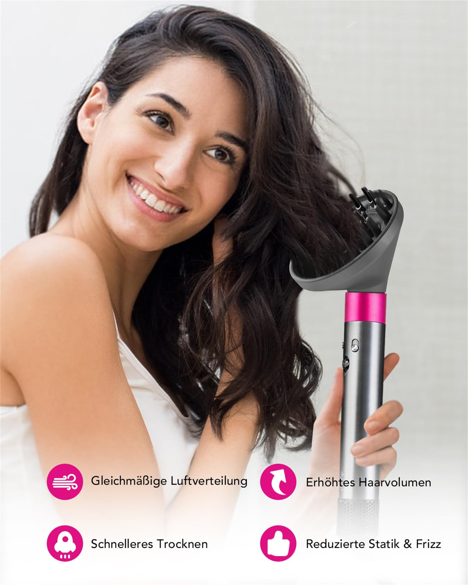 Lächelnde Frau, benutzt Föhn. Dunkles Haar, weißes Oberteil. Föhn ist silber und pink.
