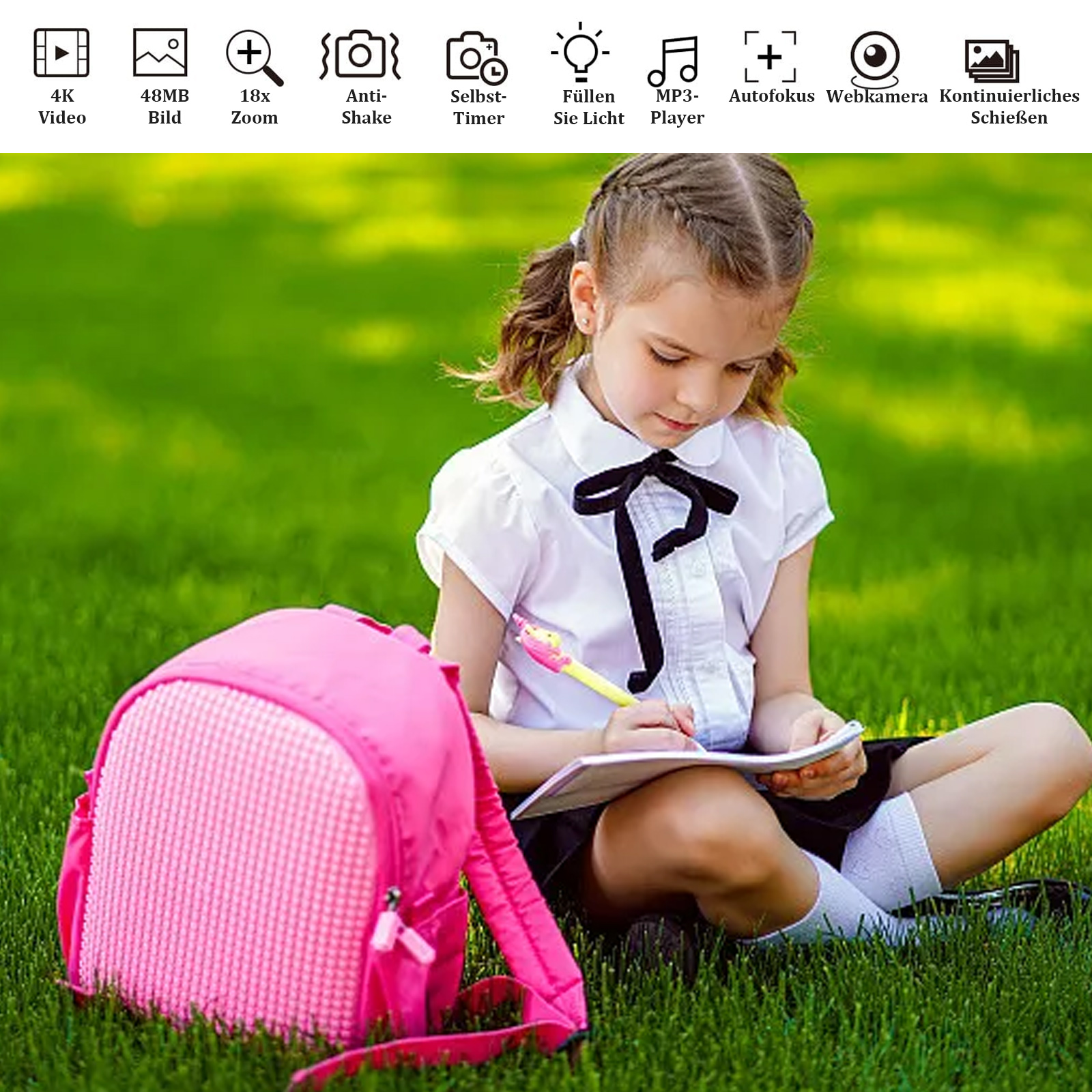 Ein Mädchen sitzt auf Gras und schreibt in ein Notizbuch. Ein pinkfarbener Rucksack liegt daneben. Der Hintergrund ist grünes Gras.
