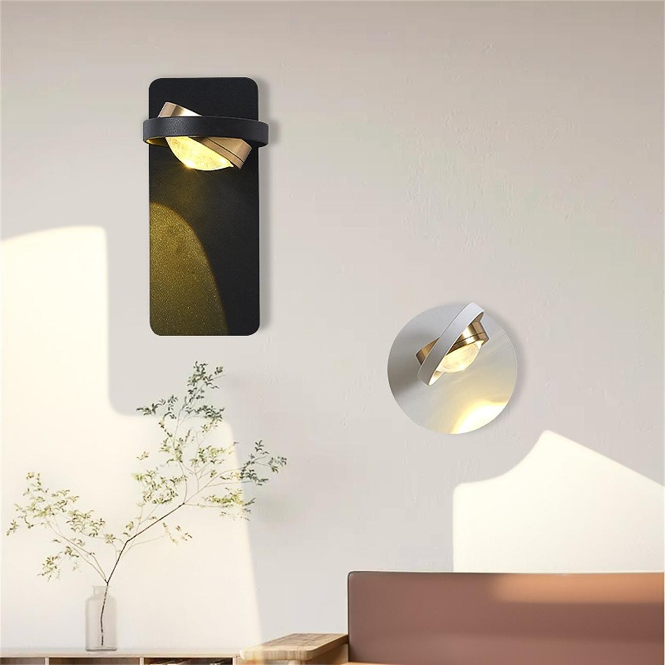 Zwei moderne Wandlampen: eine schwarze rechteckige, eine weiße kreisförmige. Beide haben goldene Akzente und geben warmes Licht ab.