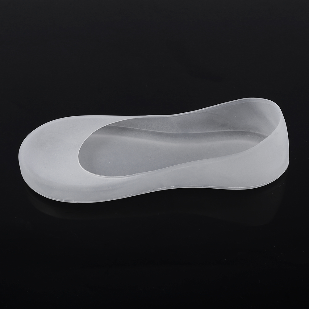 Eine durchscheinende Schuhabdeckung, geformt wie ein Ballettschuh, liegt auf einer schwarzen Oberfläche. Die Abdeckung besteht aus weichem, flexiblem Material.