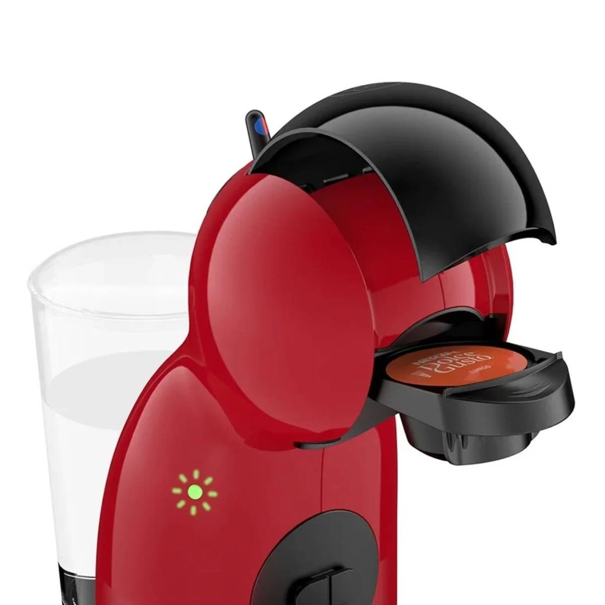Macchina da caffè rossa con dettagli neri, aperta per rivelare la capsula. Un bicchiere d'acqua a sinistra.