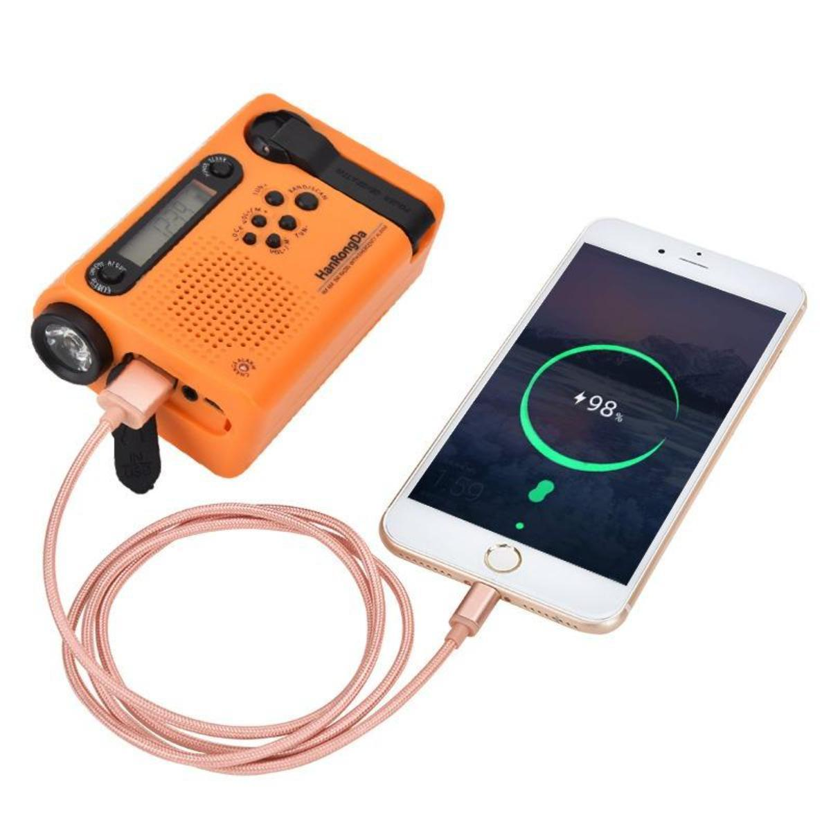 Oranges Radio lädt Telefon. Telefon zeigt 98% Akku. Rosa Kabel verbindet beide Geräte.