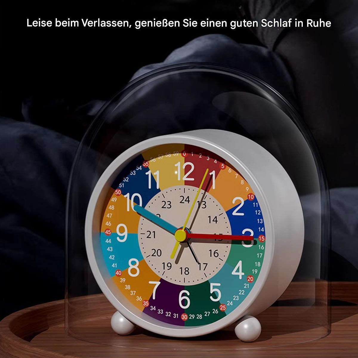 Ein bunter Wecker mit transparentem Deckel auf Holzoberfläche. Die Uhr zeigt die Zeit an.