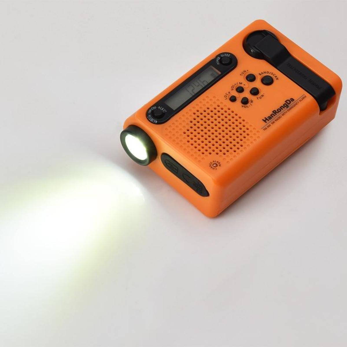 Oranges Notfallradio mit Taschenlampe, die 12:46 anzeigt. Schwarzer Griff oben. Weißer Lichtstrahl links.