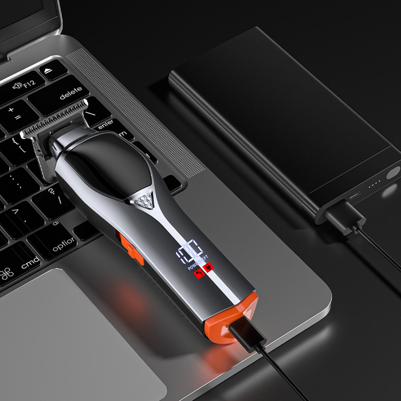 Ein Haarschneider liegt auf einem Laptop und ist an eine Powerbank angeschlossen. Der Rasierer zeigt die Akkulaufzeit. Hintergrund ist eine schwarze Oberfläche.