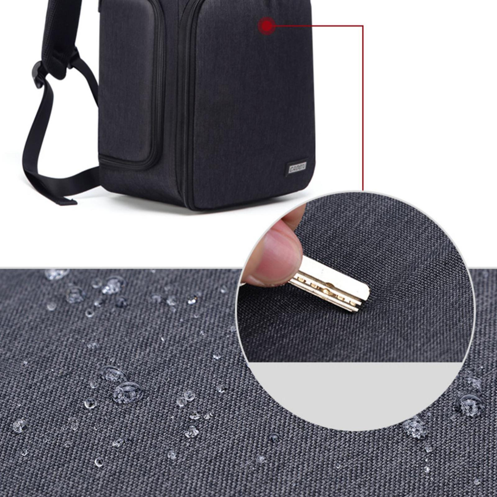Schwarze Tasche mit Wassertropfen auf dem Stoff. Eine Hand hält einen Schlüssel. Nahaufnahme zeigt die Stoffstruktur.