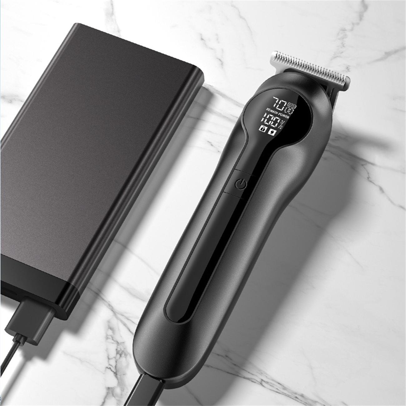 Ein schwarzer Haarschneider mit Digitalanzeige für die Akkulaufzeit liegt auf einer Marmoroberfläche neben einer schwarzen Powerbank.
