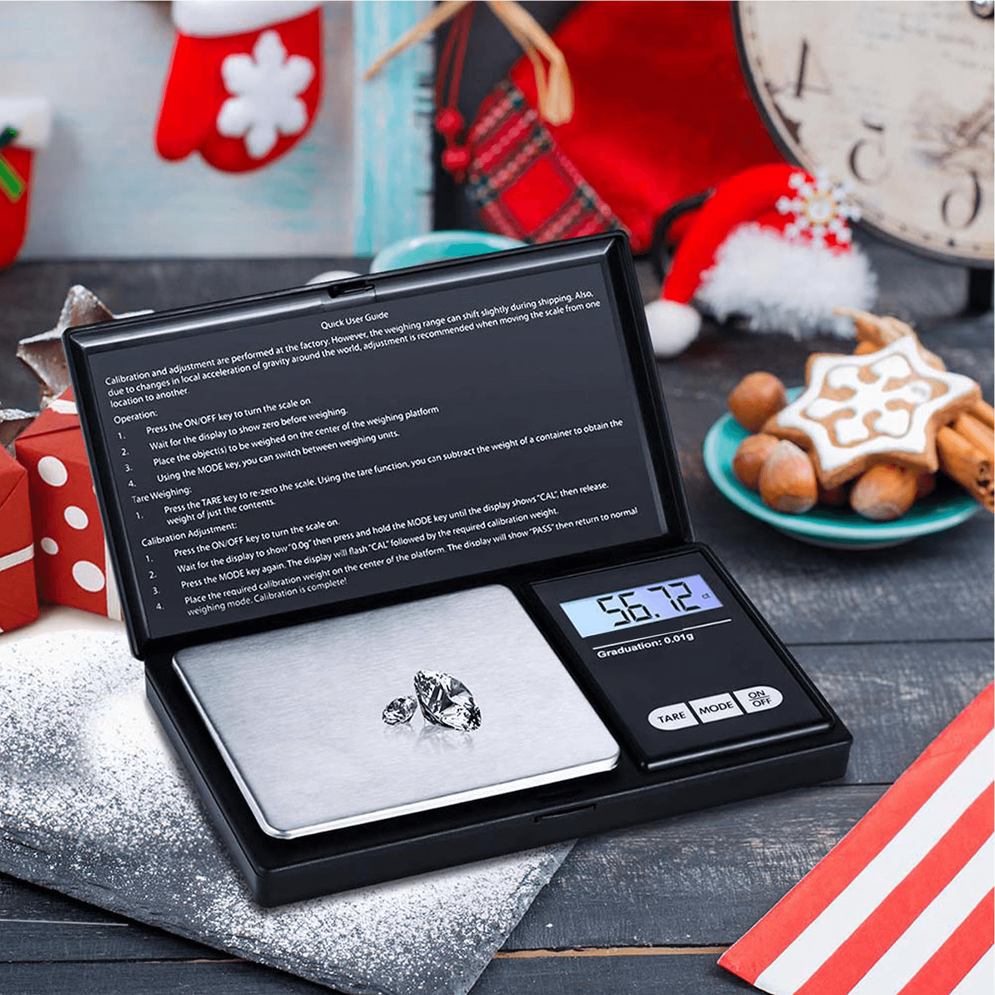 Eine Digitalwaage zeigt 56,72 g an. Zwei Diamanten liegen auf der Waage. Weihnachtsdekorationen im Hintergrund.