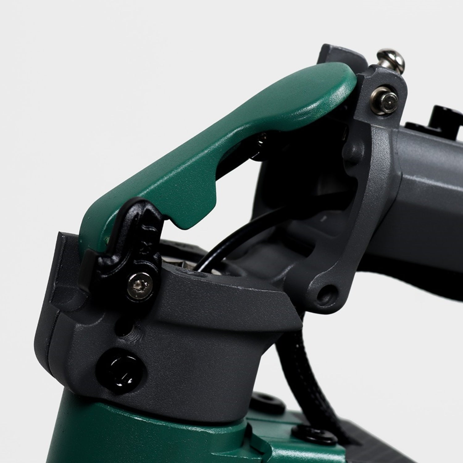 Primo piano di un meccanismo pieghevole per scooter verde e grigio. Il meccanismo è aperto, rivelando i componenti interni. Sfondo bianco.