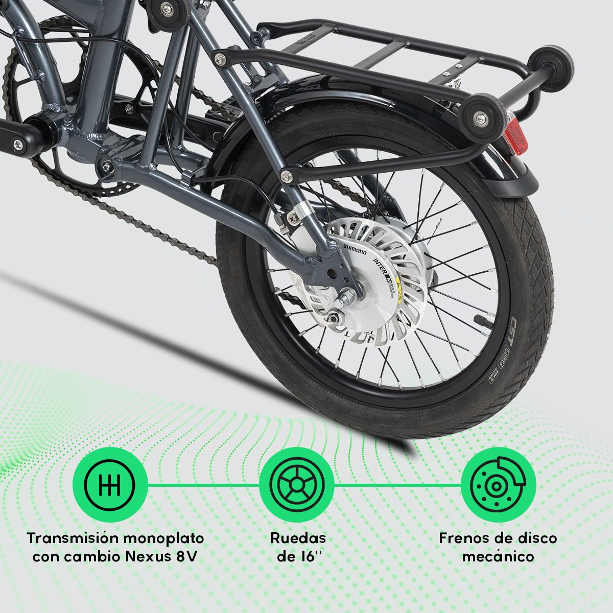 Primer plano de la parte trasera de una bicicleta gris oscura. Detalles incluyen la rueda, freno de disco, portaequipajes, cadena y Shimano Inter 8.