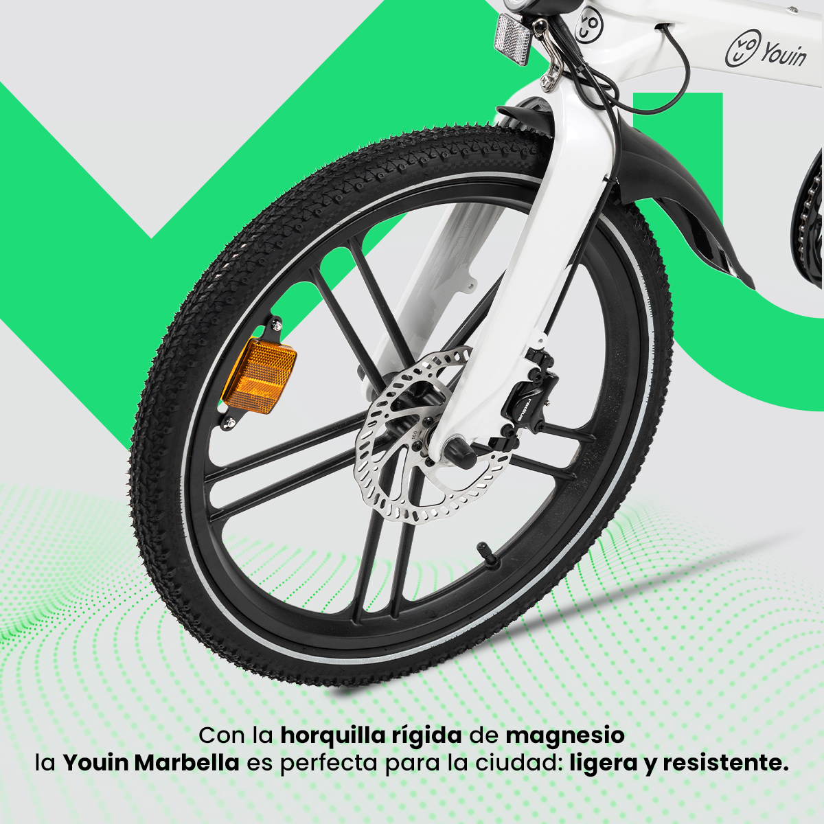 Primer plano de la rueda delantera de una bicicleta Youin Marbella blanca. Tiene un neumático negro, freno de disco plateado y reflector amarillo.