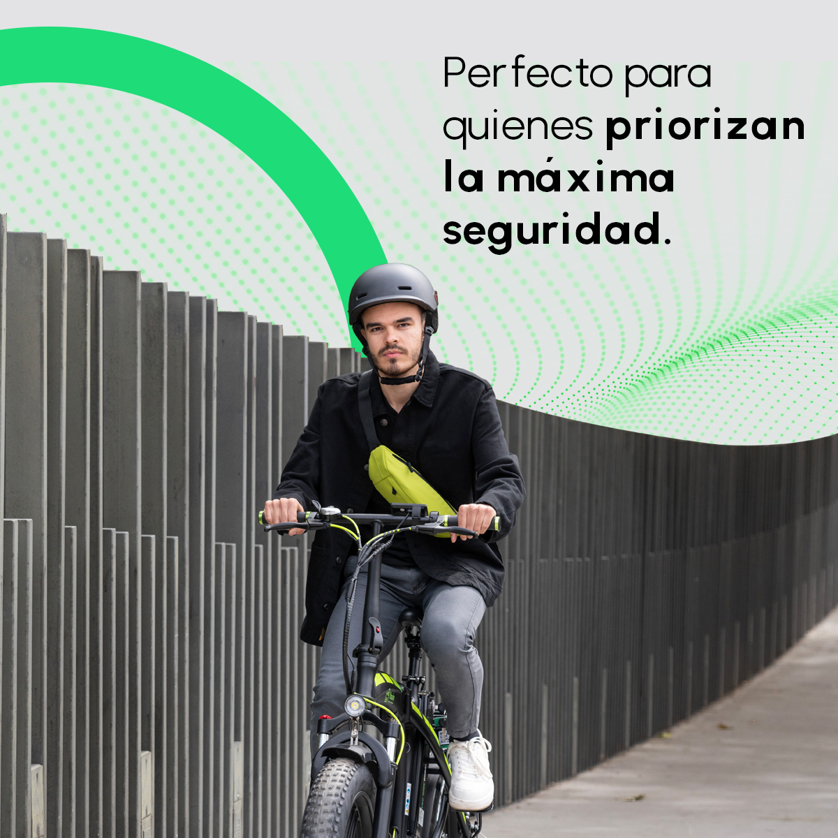 Un hombre monta una e-bike negra y amarilla. Lleva un casco y una bolsa amarilla. El fondo es una pared gris y texto verde.