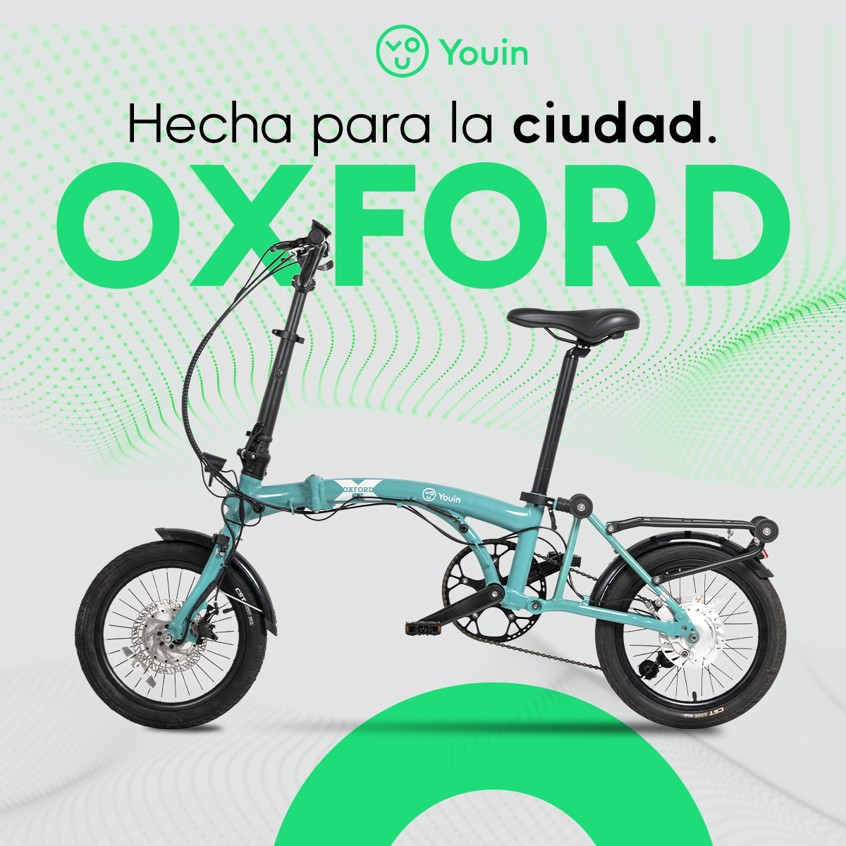 Una bicicleta plegable Youin Oxford turquesa con neumáticos, ruedas y asiento negros. El fondo tiene gráficos y texto verdes.