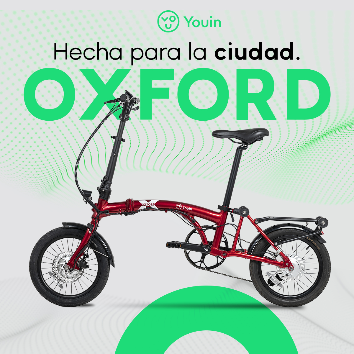 Bicicleta plegable Oxford roja sobre fondo degradado verde con texto: 'Hecha para la ciudad. OXFORD'.