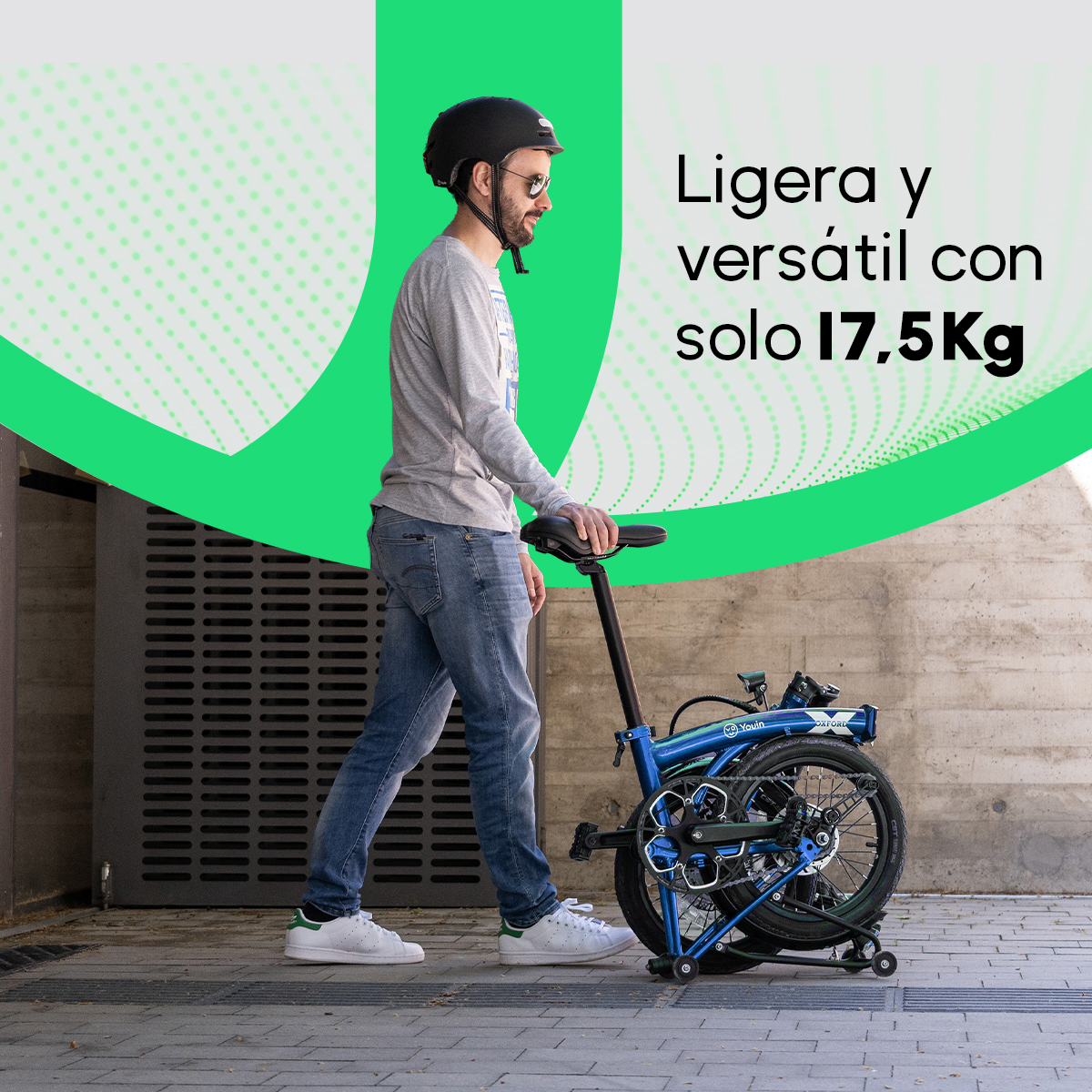 Hombre con casco camina junto a una bicicleta azul plegada. El texto dice 'Ligera y versátil con solo 17,5 kg'.