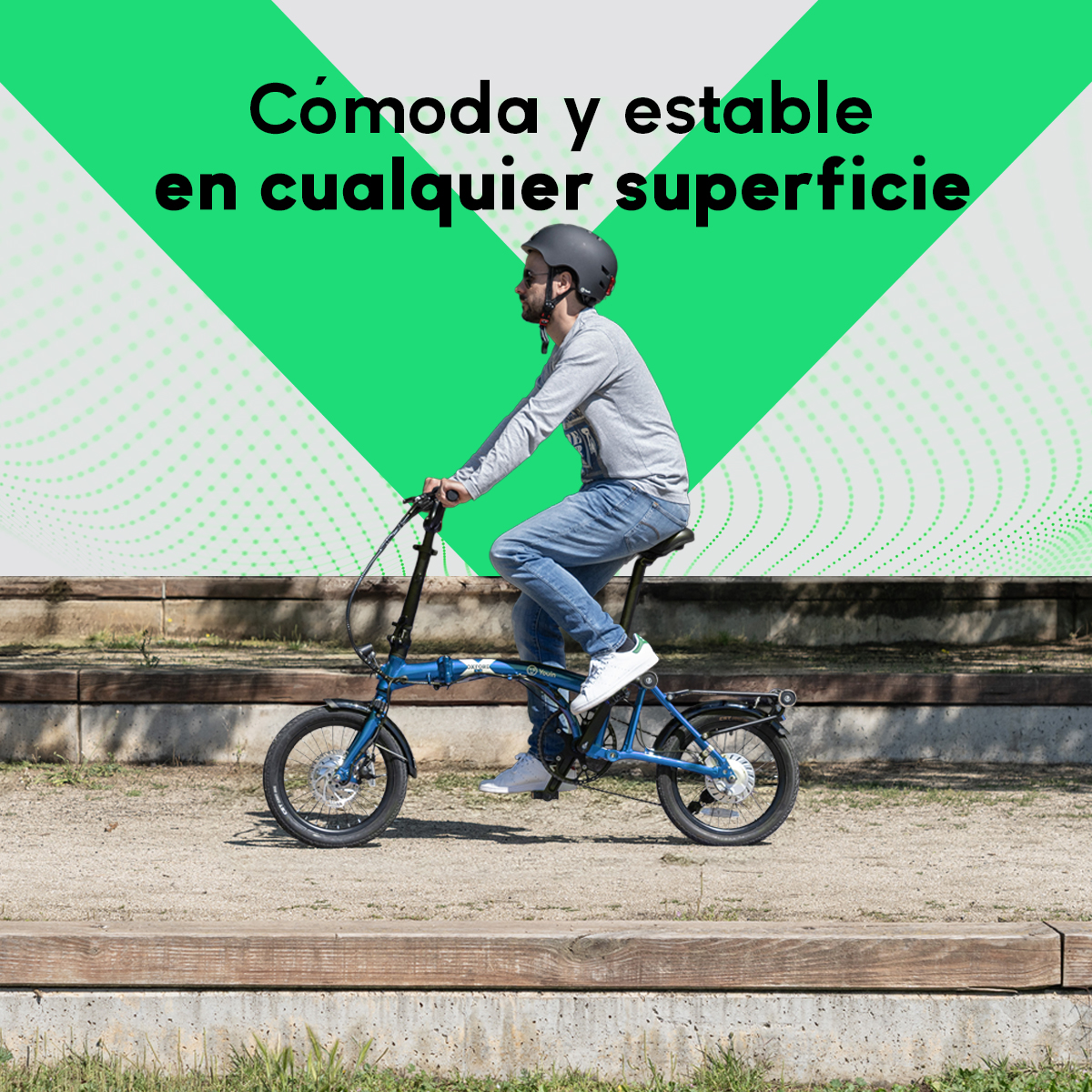 Hombre montando una bicicleta plegable azul en un camino. Lleva casco, vaqueros y zapatos blancos. Gráfico verde al fondo.