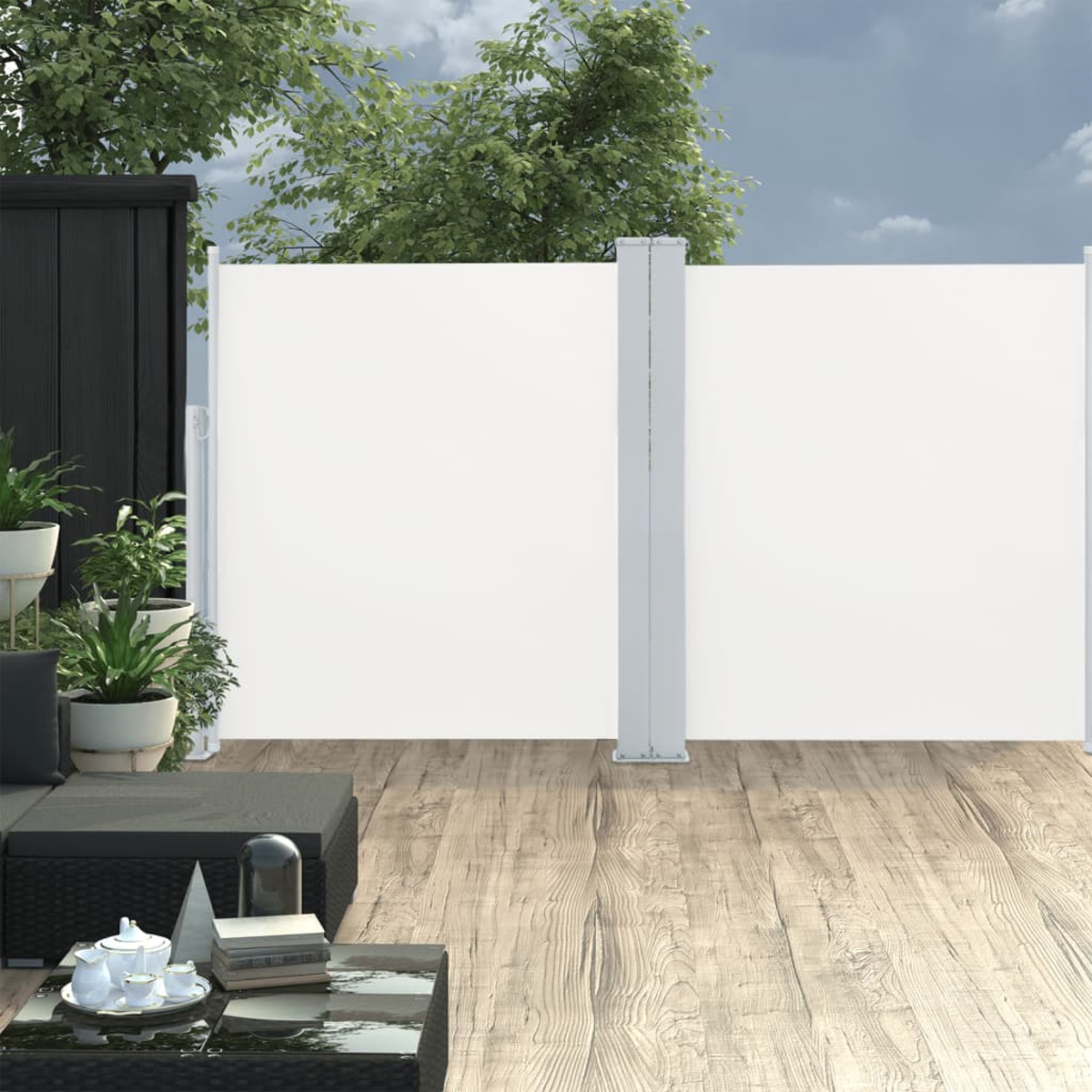 Außenszene mit weißer Wand, schwarzem Sofa, Pflanzen, Tisch mit Teeservice und Holzterrasse. Bäume und Himmel im Hintergrund.