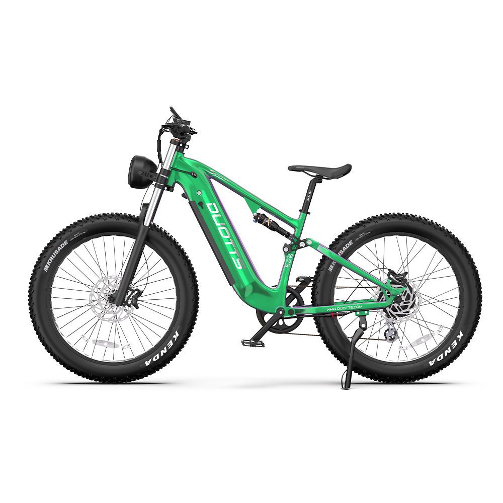 Bicicleta eléctrica verde con neumáticos y asiento negros. La marca 'DUOTTS' es visible en el cuadro. Llantas Kenda.