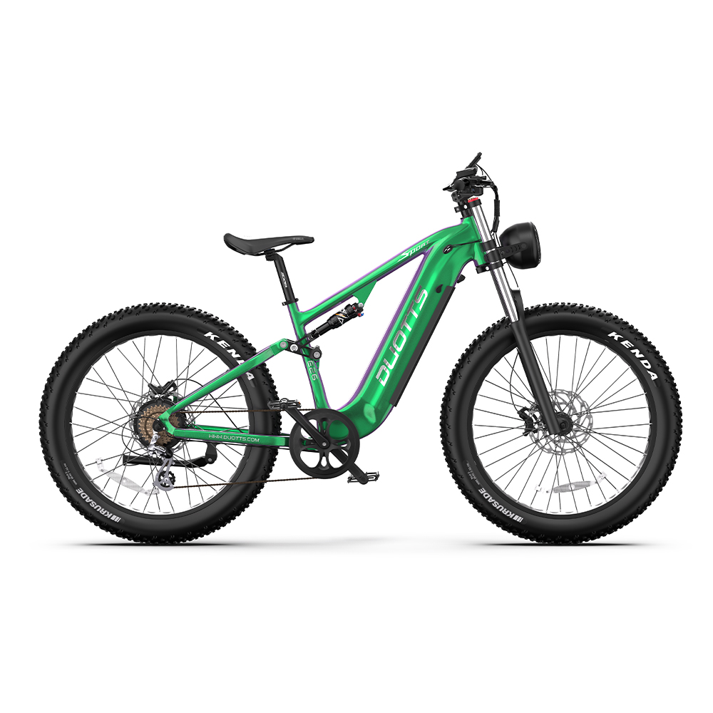 Bicicleta de montaña eléctrica verde y morada con neumáticos negros, asiento negro y faro, aislada sobre fondo blanco.