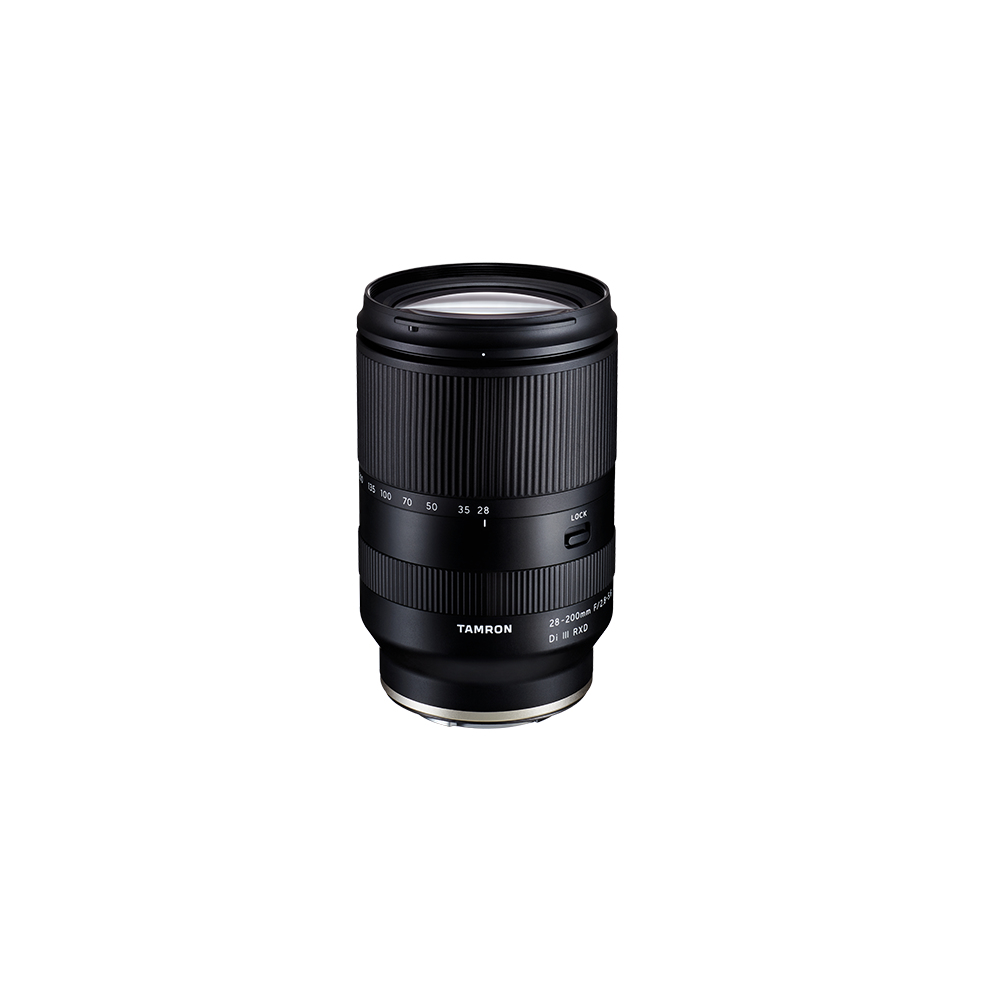 Una lente negra Tamron 28-200mm se alza sobre un fondo blanco. Tiene marcas numéricas y un interruptor de bloqueo.
